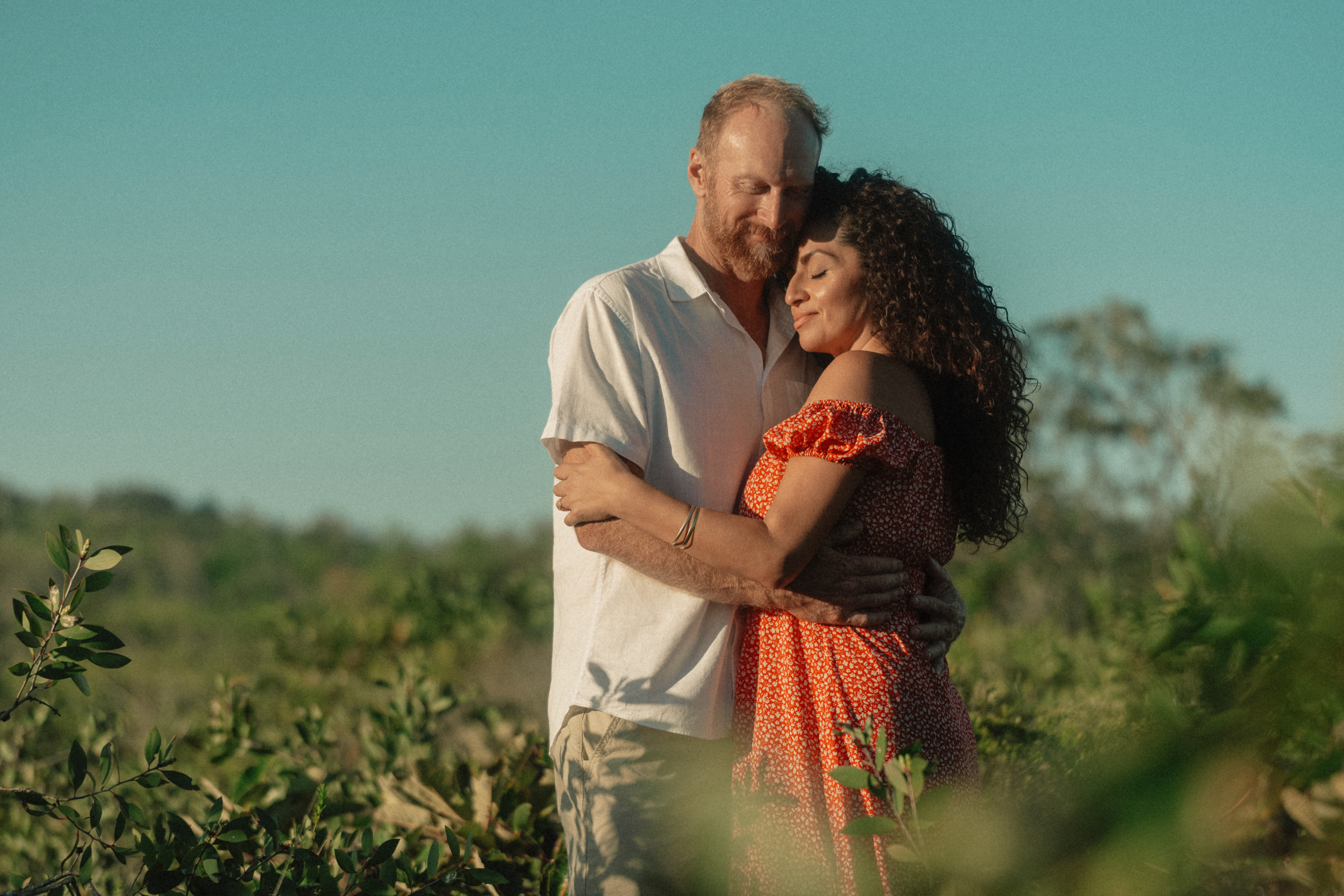 Embracing in sunlit field